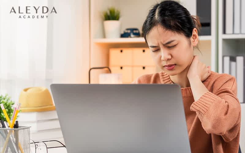 Exhausted young woman sitting in front of laptop