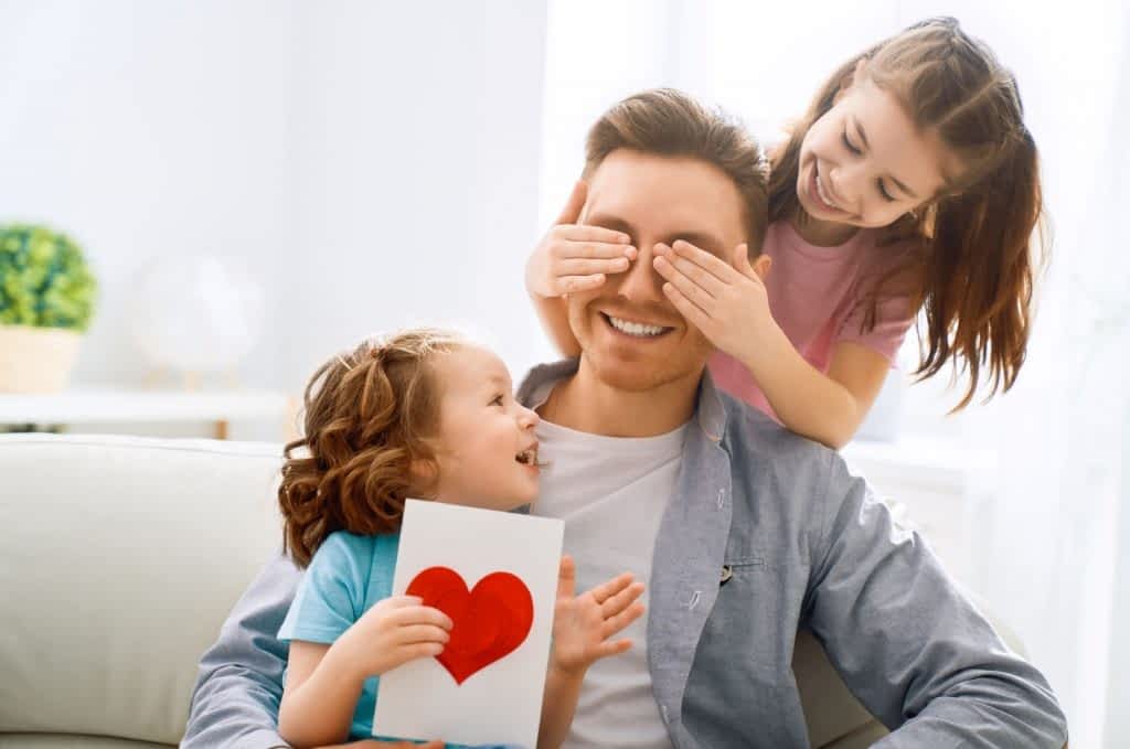 Father-covered-eyes-by-kids-with-heart-card