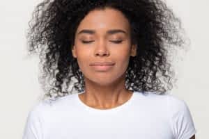 woman-closed-eyes-in-white-shirt